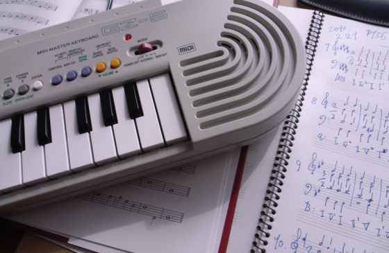 image presenting a sheet music and a MIDI keyboard, in a web page related to music research, music technology and the YMusic search engine