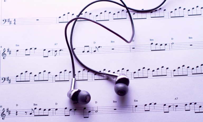 image representing a sheet music and earphones, in a web page related to music research, music technology and the YMusic search engine